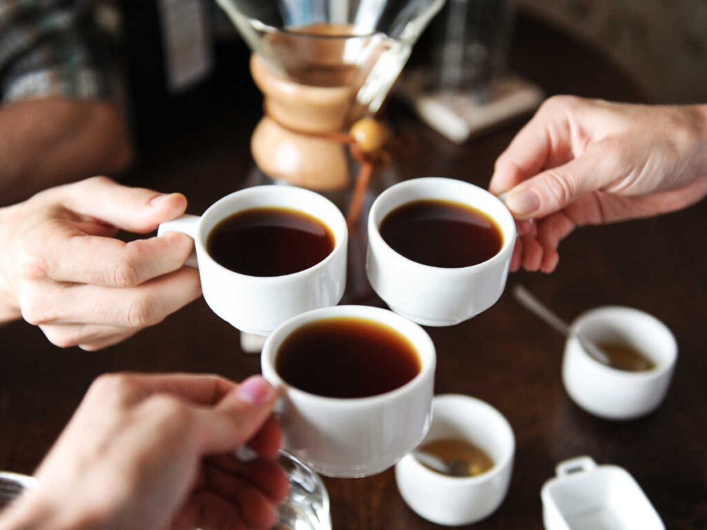 A group of people clinking the cups of coffee at Don Pello Coffee