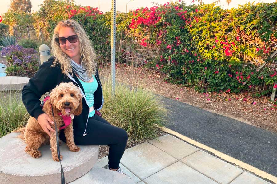 The author and her dog sitting on a bench at the Coastal Rail Fairy Trail