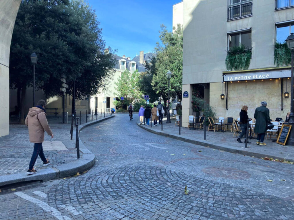 People stroll along a cobblestone street in Paris