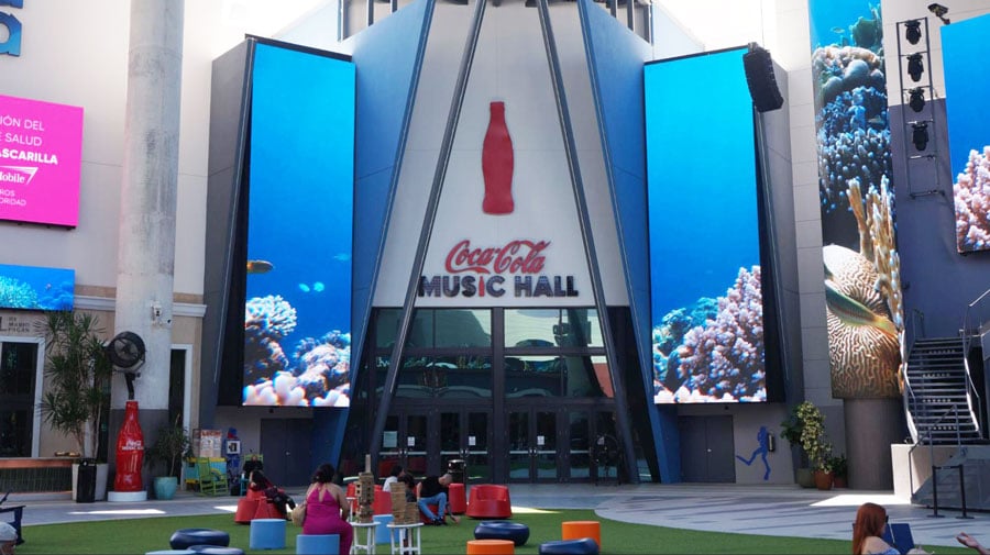 View of the Coca Cola Music Hall entrance and people sitting outside it