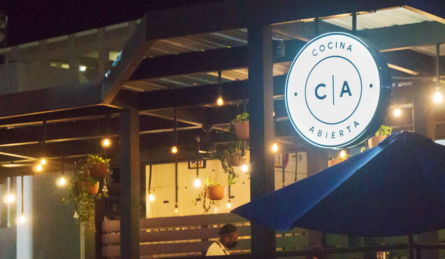 The Cocina Abierta sign illuminated with light at night
