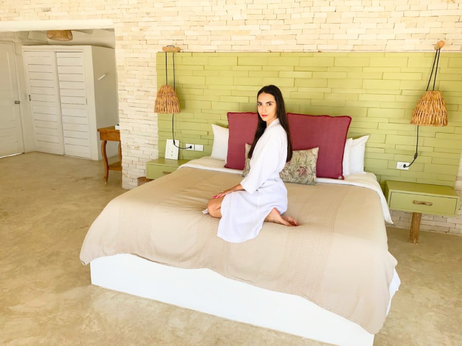 Clara sitting on the bed in Coco Limited Tulum Hotel