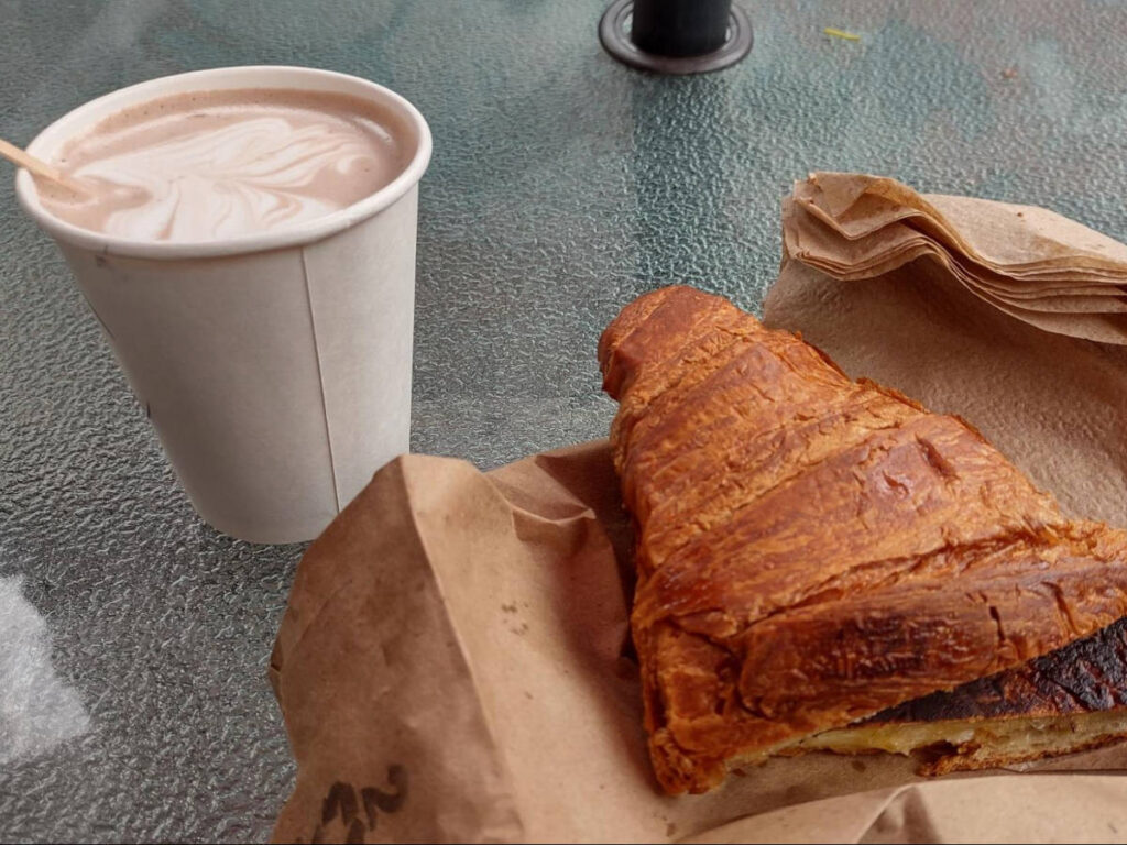 Closeup look of a cup of coffee and croissant