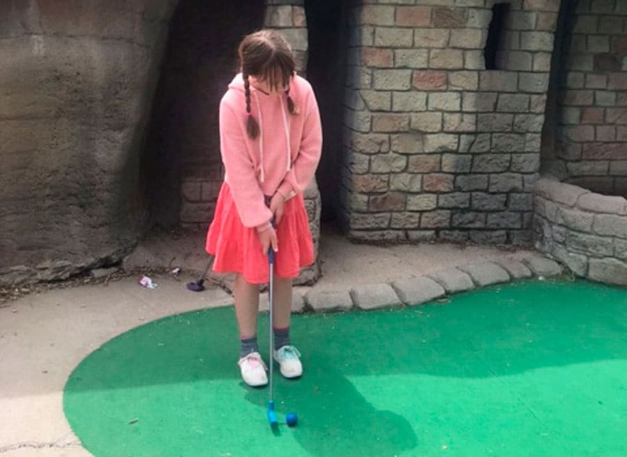 A girl playing golf in a mini golf course in Colorado Journey Mini Golf