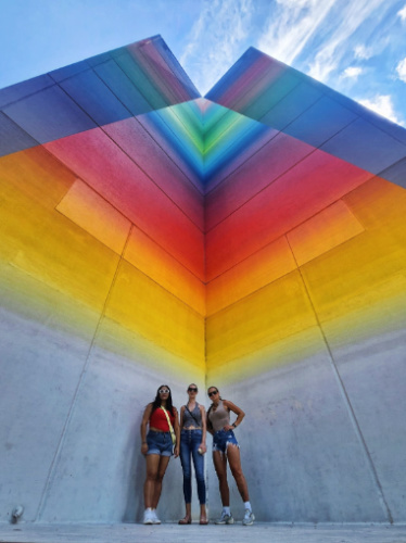 The author Niamh Hayes with her friends and a colorful building in Austin