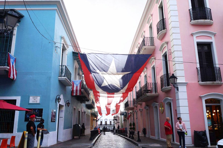View of the colorful houses in an alley with the big Puerto Rico flag at the middle