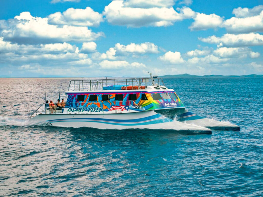 A colorful catamaran sailing on the turquoise blue water