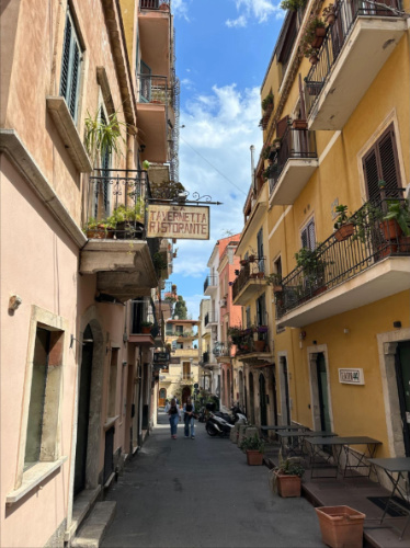 View of colorful buildings on a street in Taormina