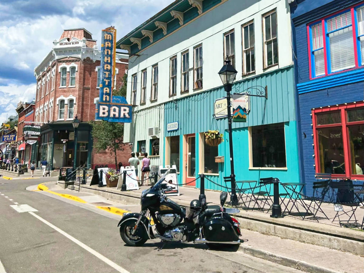A vintage motorbike in front of the colorful Victorian architecture in downtown Leadville 