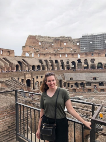 The author, Elizabeth Demolat smiling for a photo at Colosseum in Rome