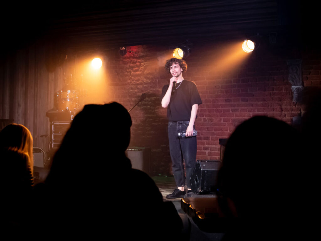 A comedian performing his stand-up monologue on a stage