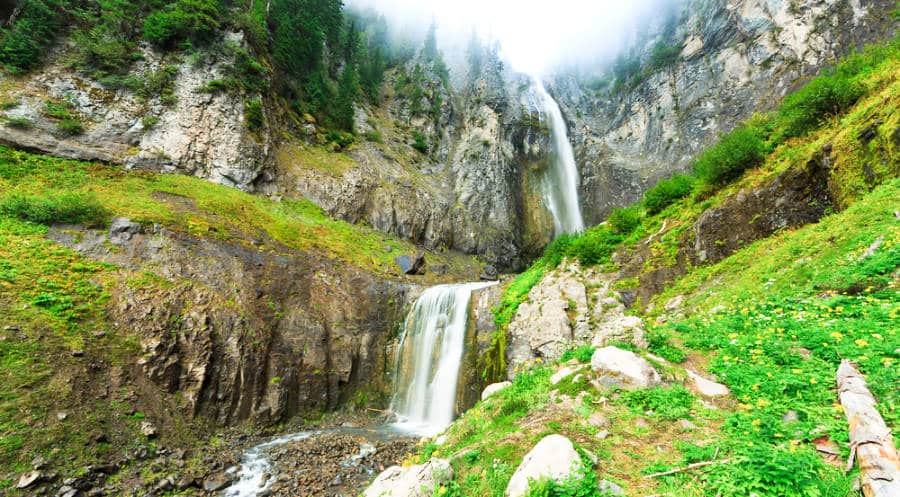 View of the stunning cascading waterfall with a layer of fog above