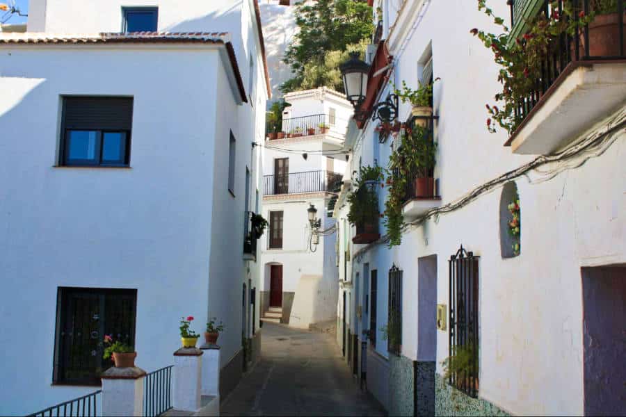 A narrow street in between the white buildings of Cómpeta's small town.
