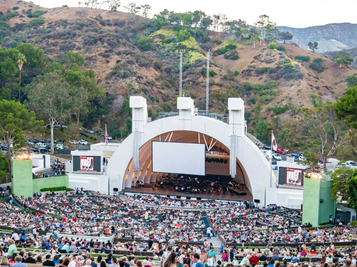 The crowd watching the concert at the Hollywood Bowl amphitheater with nature views in the background