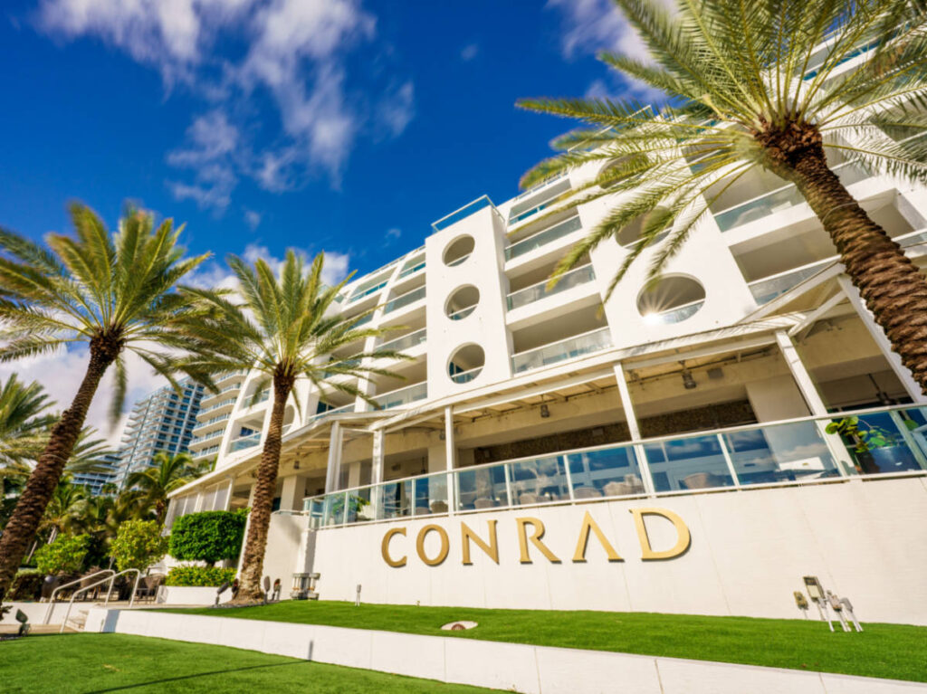 Exterior view of Conrad Hotel surrounded by palm trees