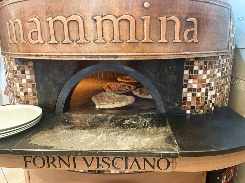 View of the pizzas cooking inside the furnace in Naples