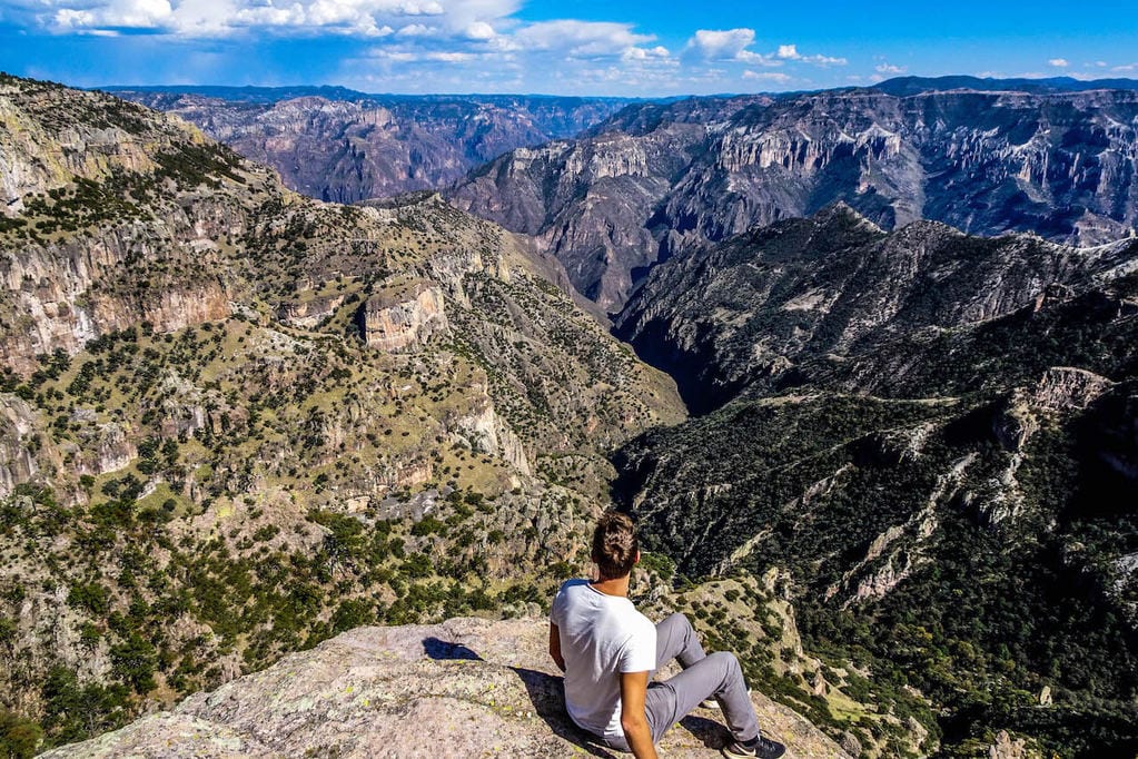 A man sits on the edge of Copper Canyon, taking in the breathtaking view
