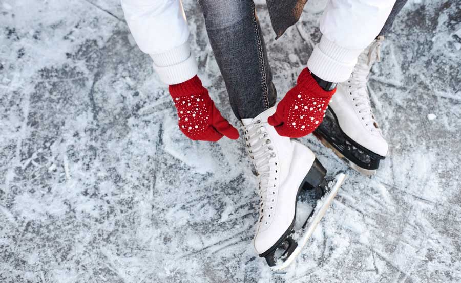 View of a woman tying her shoelaces on her ice skate shoes