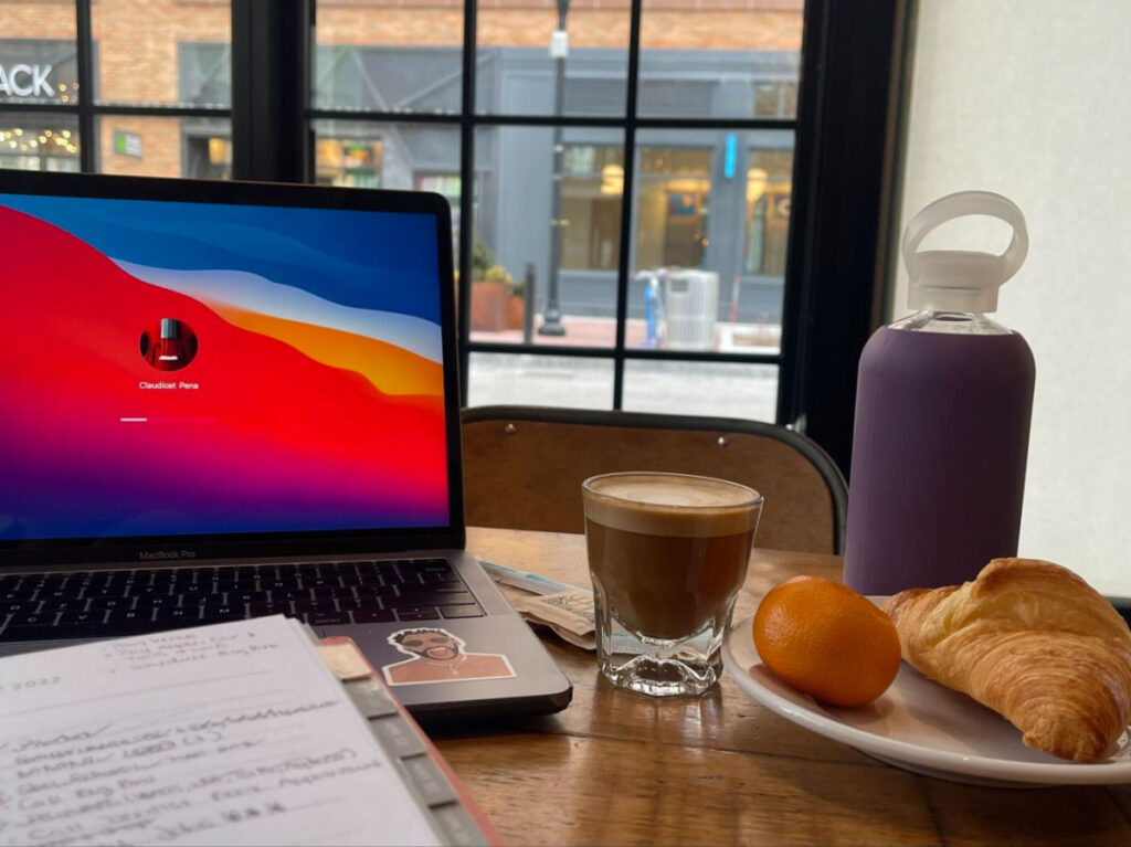 Authors laptop next to the Cortado and croissant at Caffe Nero