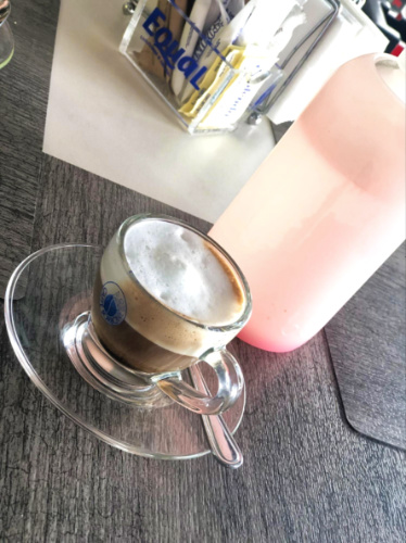 A cup of cortado and a bottled water