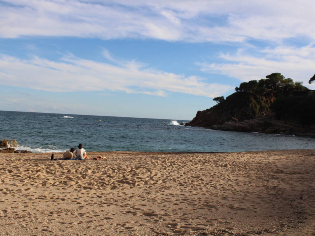 A couple relaxing along the shoreline on Cala Bona