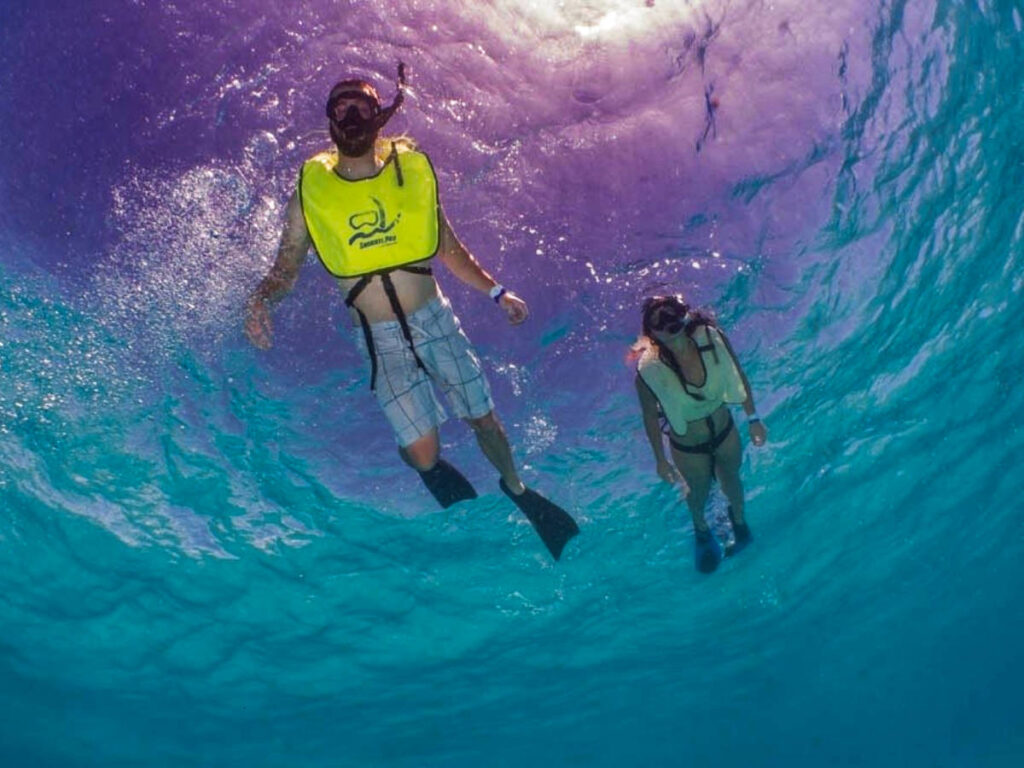 A couple snorkeling on the turquoise blue water in Culebra, seen from under the water