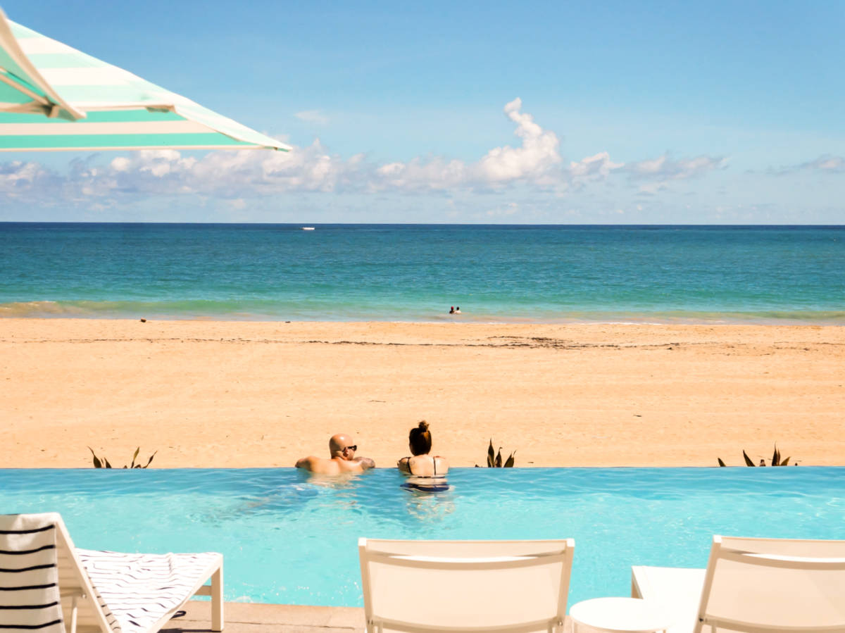 A couple swimming on the pool overlooking the beach