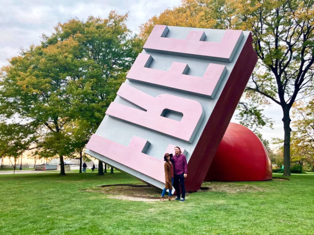 Travel Lemming editor Abigail Bliss and her husband posing in front of The Free Stamp in Willard Park