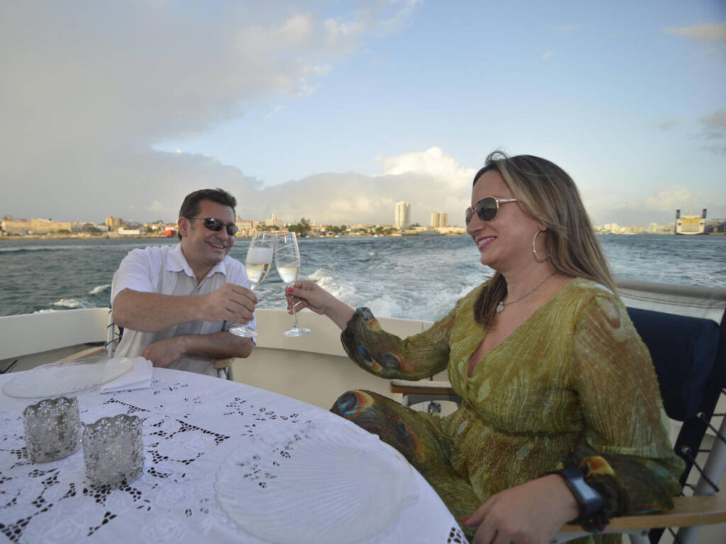 A couple clinking wine glasses on the boat cruise