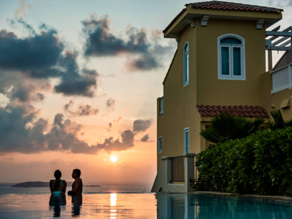 A couple swimming on the pool at El Conquistador Resort at sunset