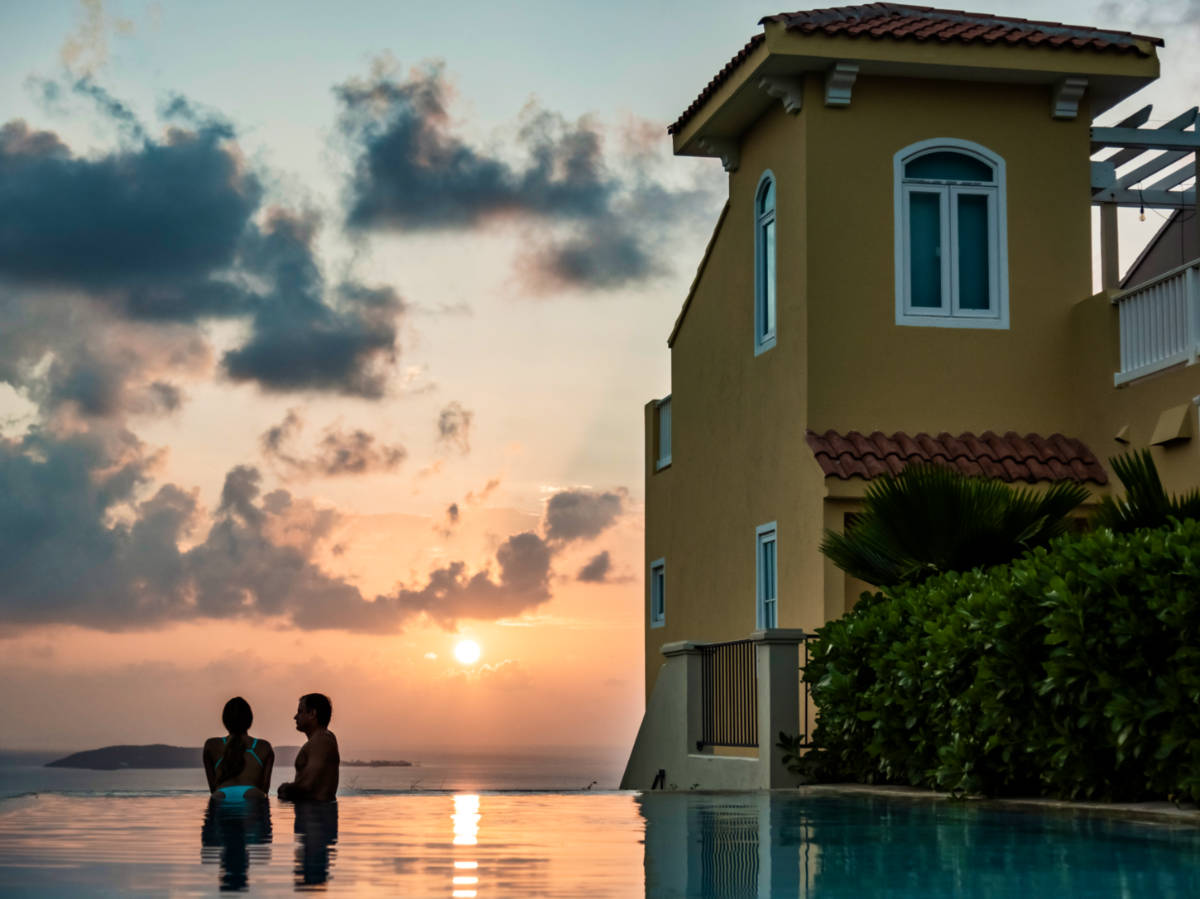 A couple swimming on the pool at El Conquistador Resort at sunset