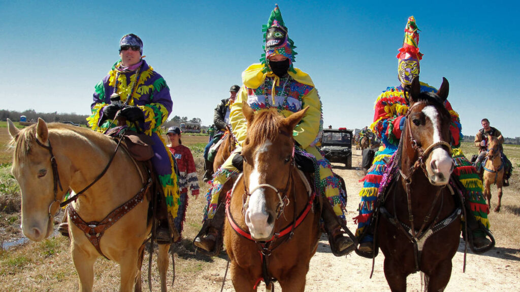 Men on costumes riding a horse during Courir de Mardi Gras