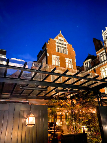 Night view of the outdoor area of Chiltern Firehouse with a clear blue sky in the background