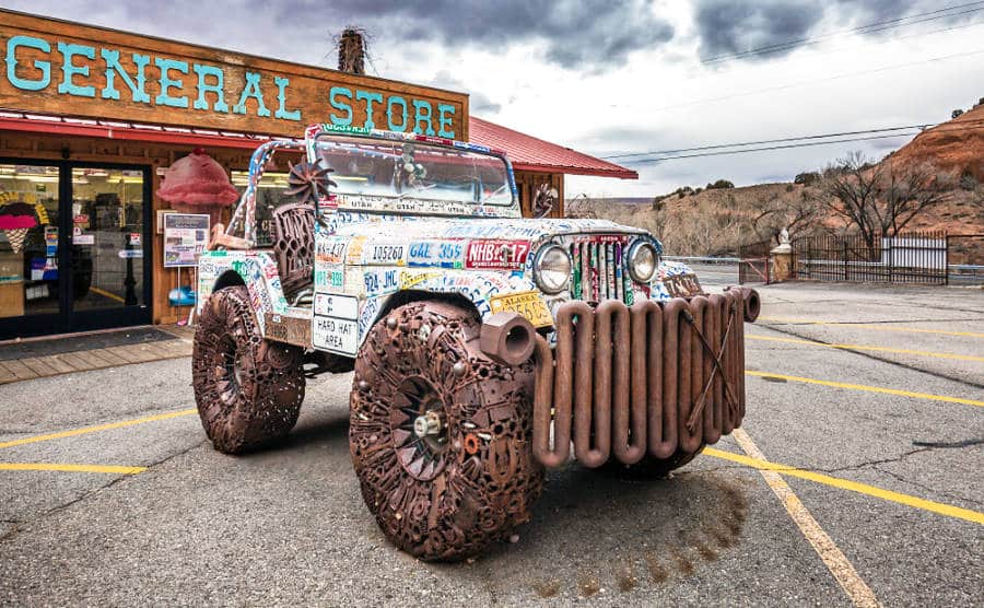 A jeep covered with old license plates and built with old tools and random mechanical parts