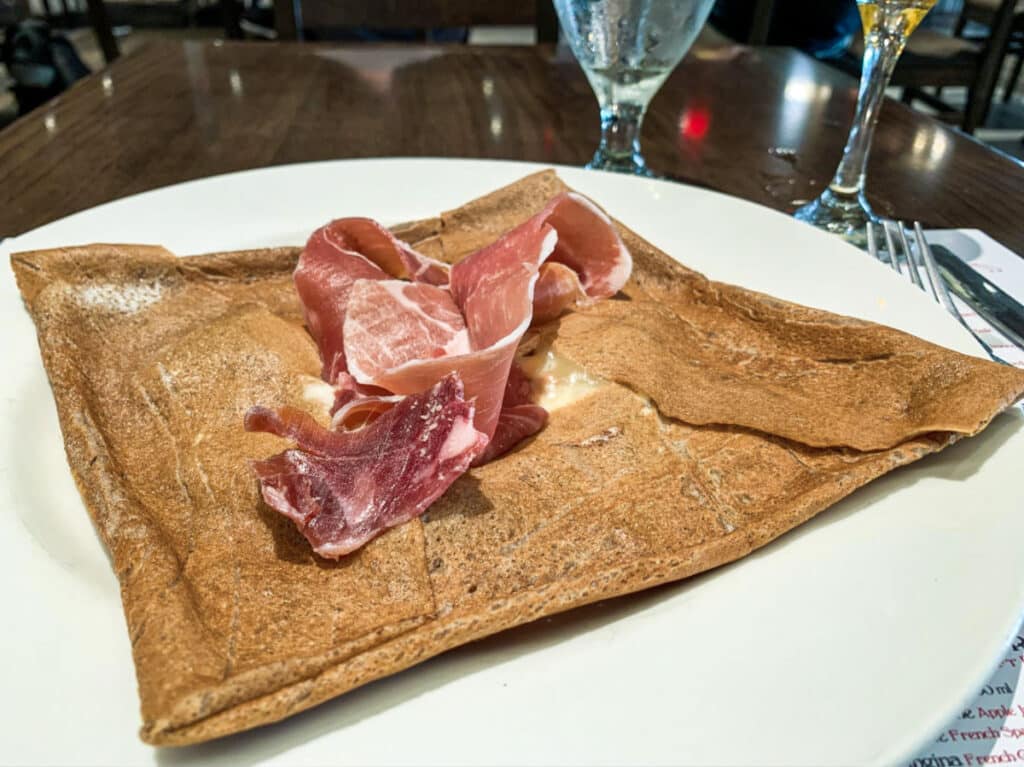 A plate of crepe topped with bacon from La Creperie de Paris