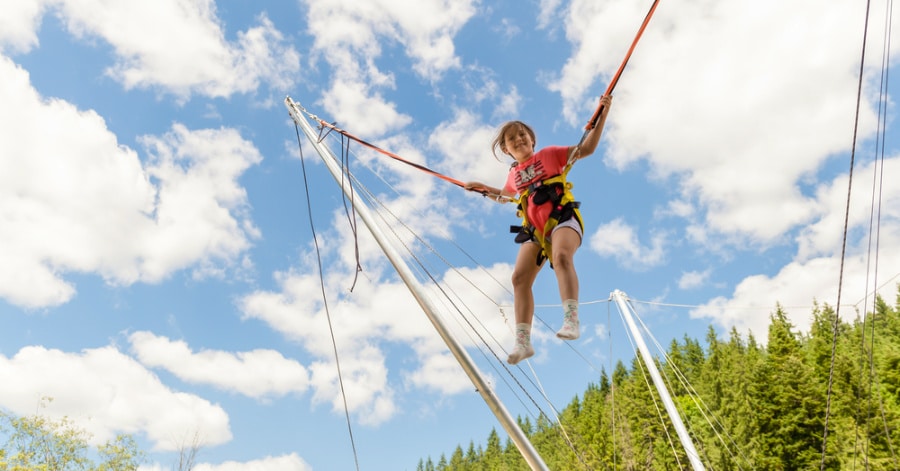 A kid playing on the bungee jumping trampoline