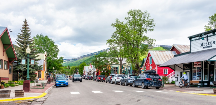 Colorful shopping stores and parked cars with a scenic view in downtown Crested Butte