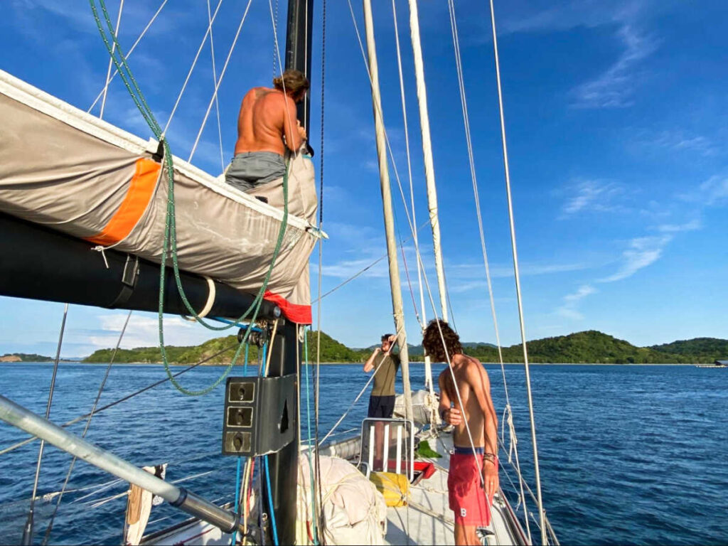 The sailing crew lowering the mainsail of the boat