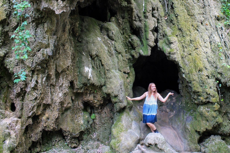 Taylor stands in front of the mouth of a cave in Krka National Park, Croatia