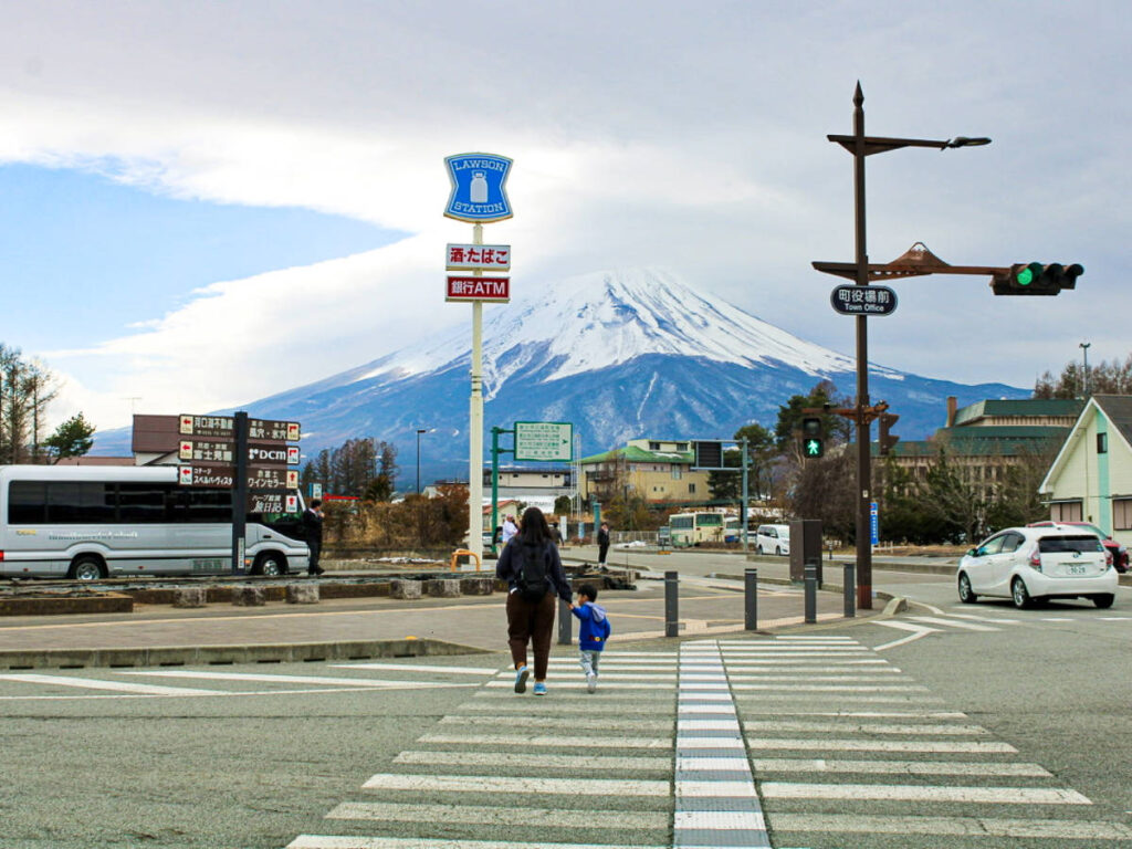 A mother and daughter crossing on the pedestrian with the views of Mount Fuji