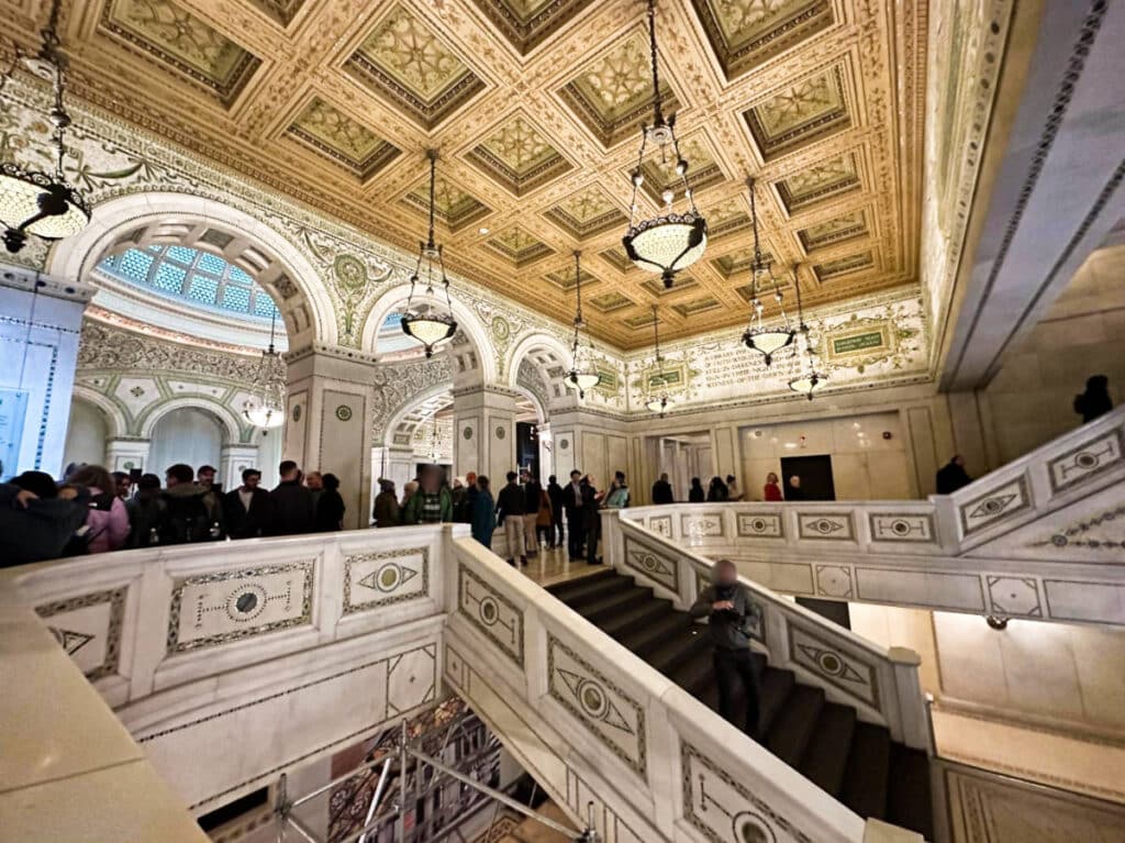 View of the crowd inside the intricate interior of Chicago Cultural Center
