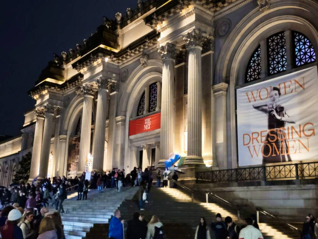 View of the exterior and the crowd at The Metropolitan Museum of Art at night