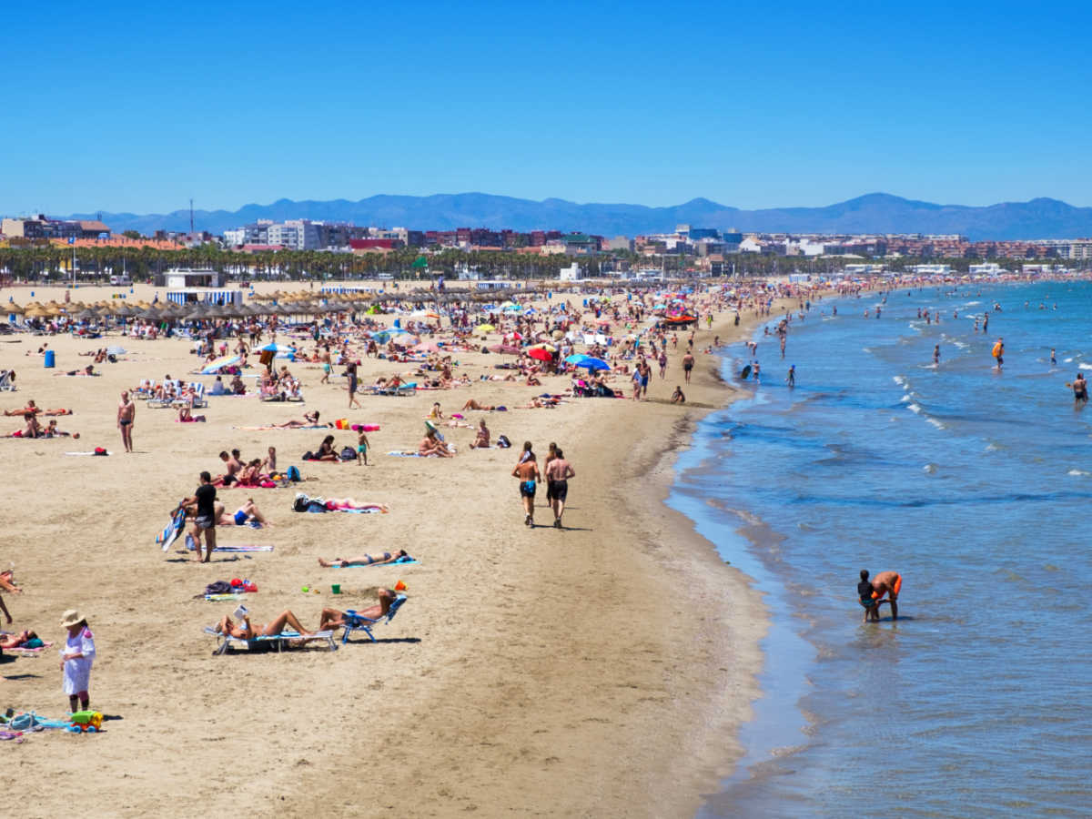 Aerial view of the crowd enjoying along the shoreline of the beach in El Cabanyal on a sunny day