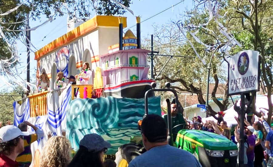View people watching the colorful float at the Uptown Mardi Gras parade