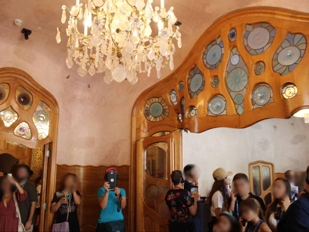 View of the chandelier and the tourists inside the Casa Batlló