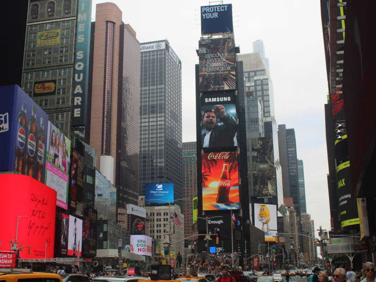 Crowded city street in Times Square with bustling pedestrians and animated LED signs