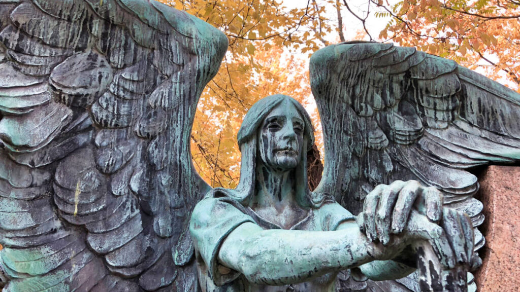 Closeup view of the crying angel statue with the fall foliage in the background at Lake View Cemetery