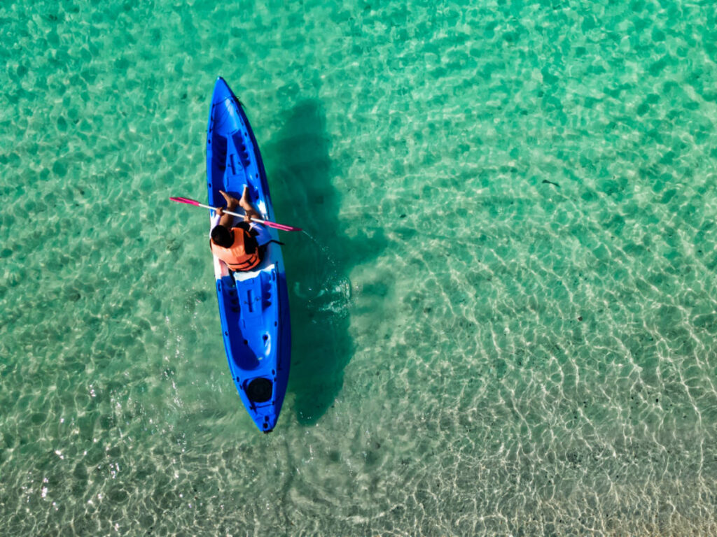 Aerial view of a man kayaking on the crystal clear water in Culebra