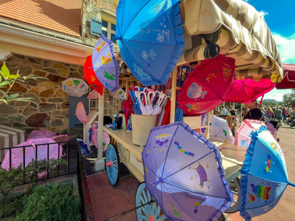 Colorful umbrella stand selling custom souvenirs at Magic Kingdom.
