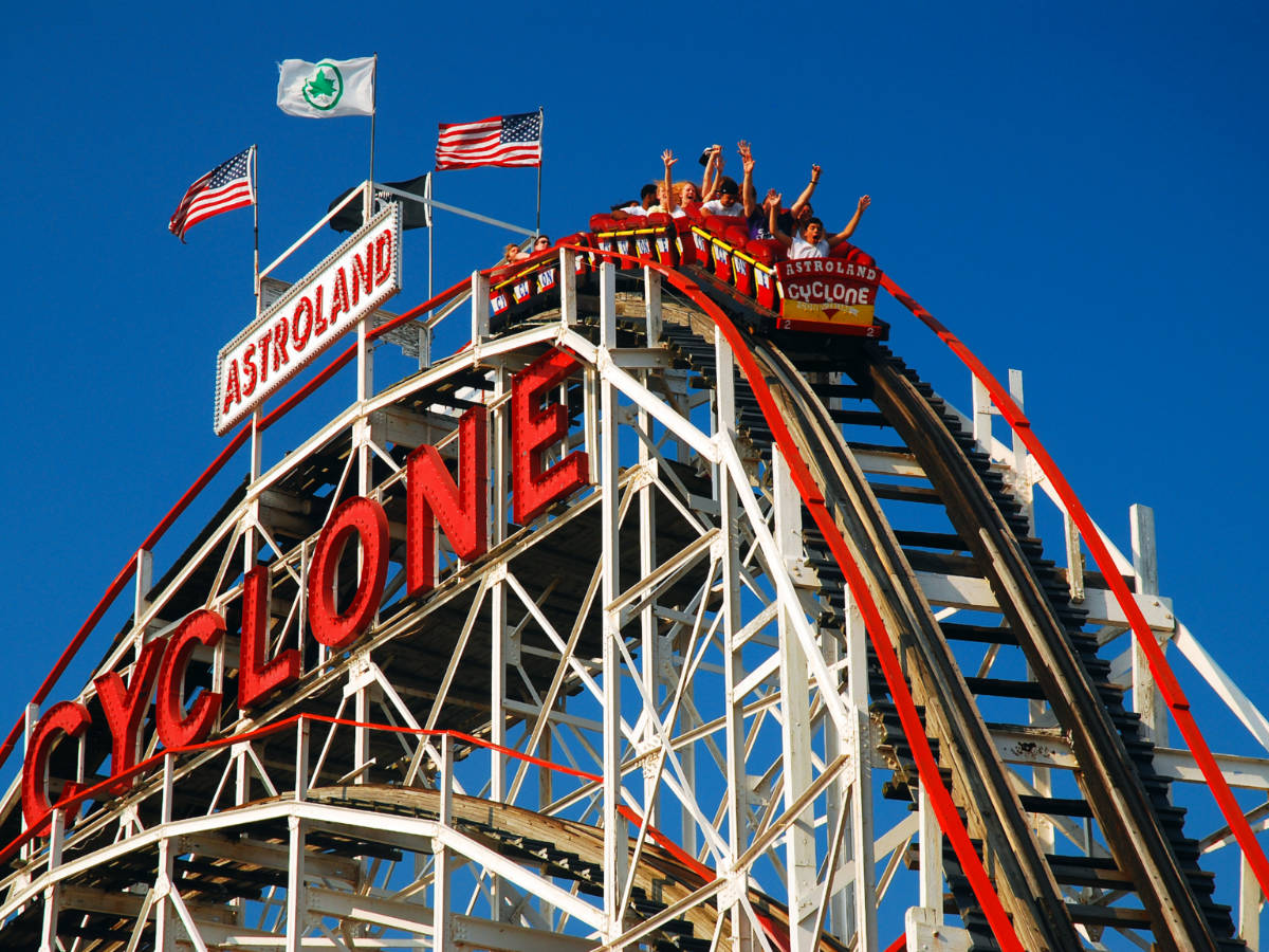 Riders raise their arms on the Cyclone roller coaster in Coney Island